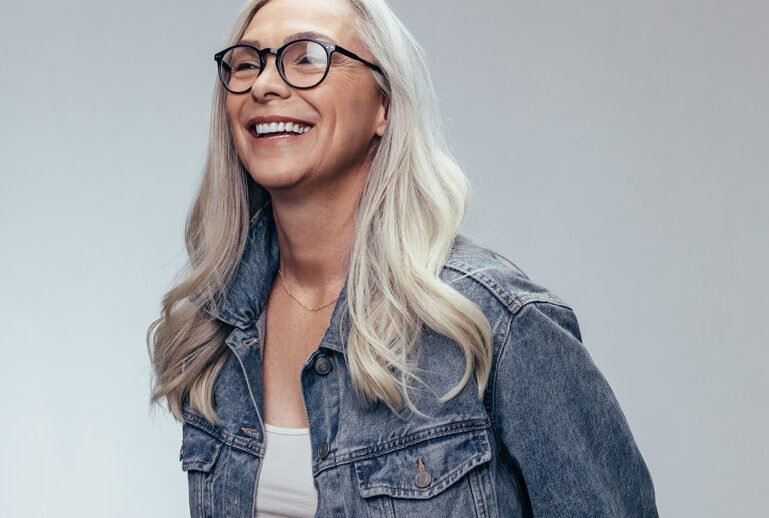 non-surgical facelift patient model smiling and wearing a jean jacket